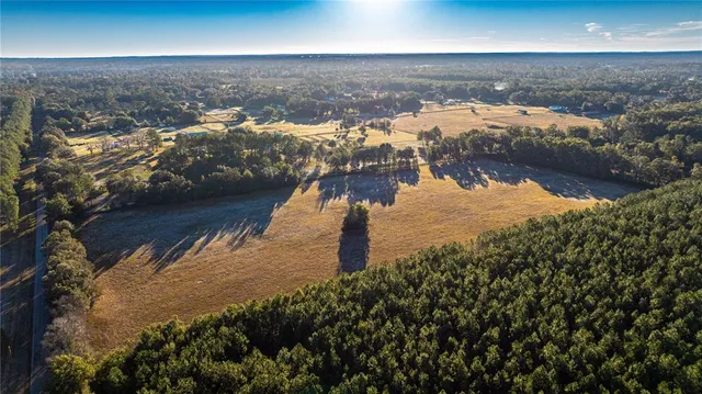 an aerial view of ocean and residential houses with outdoor space