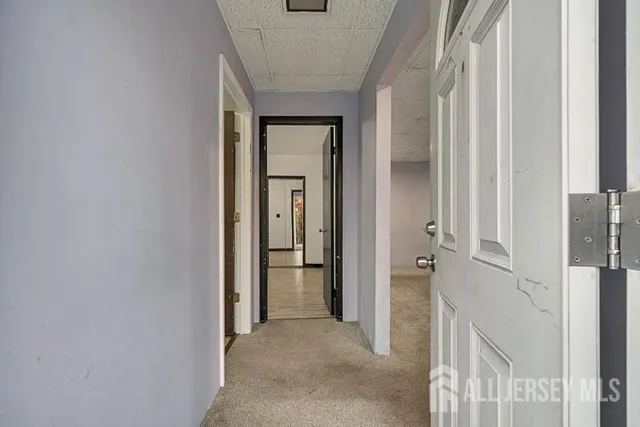 a view of a hallway with closet and bathroom