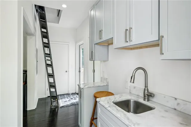 a kitchen with stainless steel appliances granite countertop a sink and a wooden floor