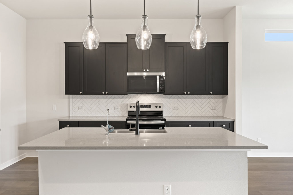 2205 Cento Walk Round Rock, TX 78664 - Photo 5 of 26 Kitchen with decorative backsplash, dark wood-style flooring, and light stone countertops