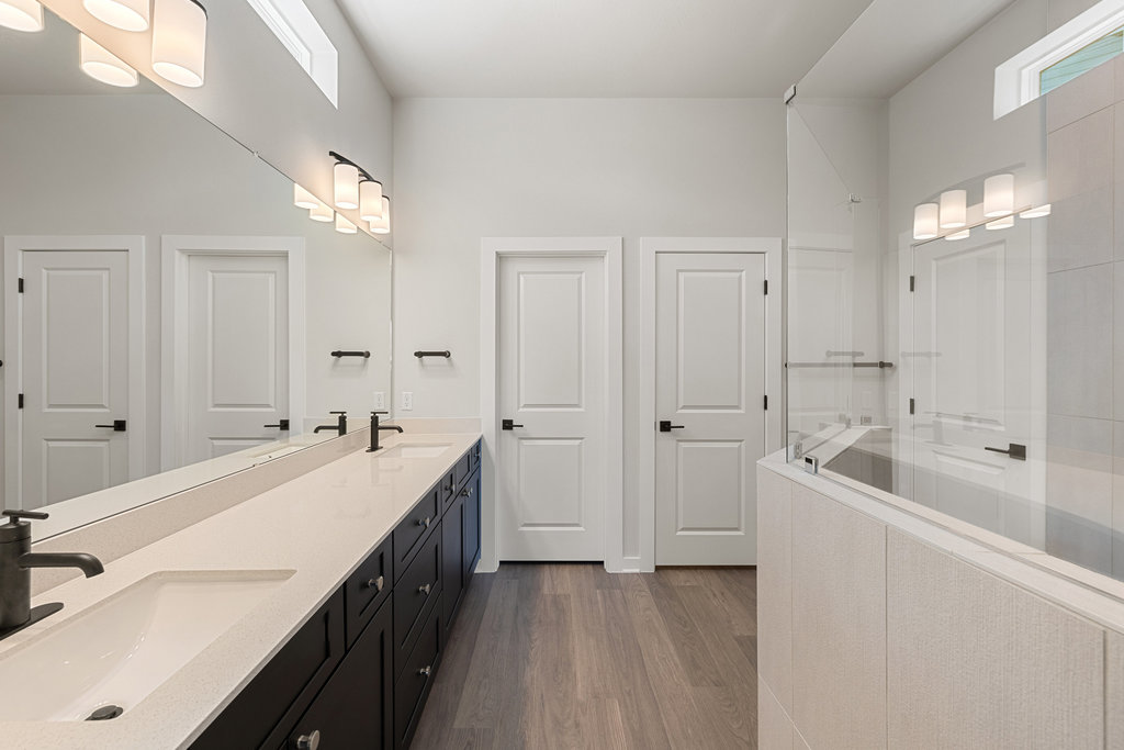 2205 Cento Walk Round Rock, TX 78664 - Photo 9 of 26 Bathroom with double vanity, dark wood-type flooring, and walk in shower