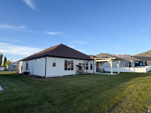 412 West 3025th Street South Logan, UT 84321 - Photo 6 of 34 Back of property featuring a lawn, a patio, and roof with shingles