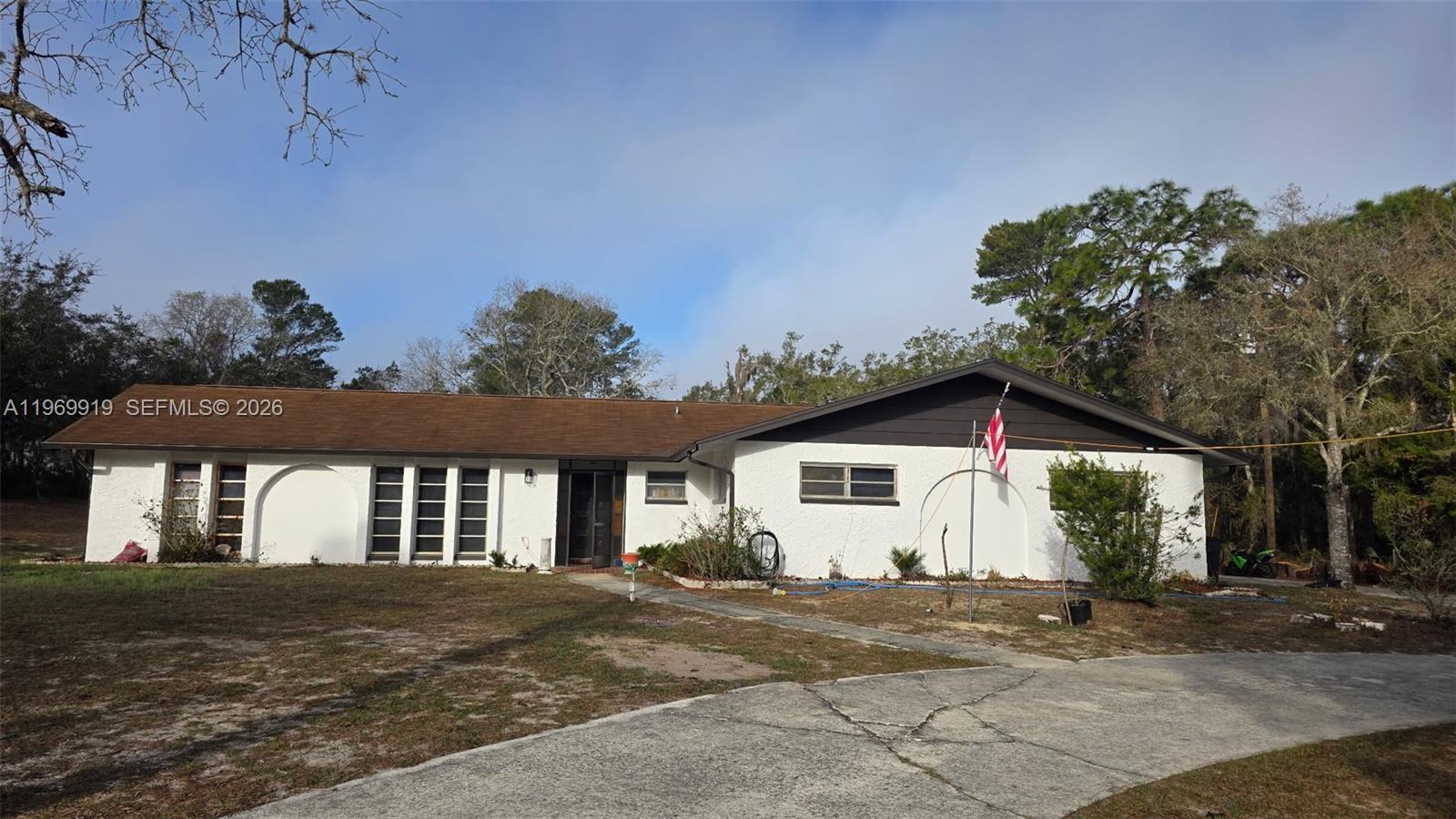 18227 Branch Road Hudson, FL 34667 - Photo 1 of 17 a view of a white house with a yard and outdoor space