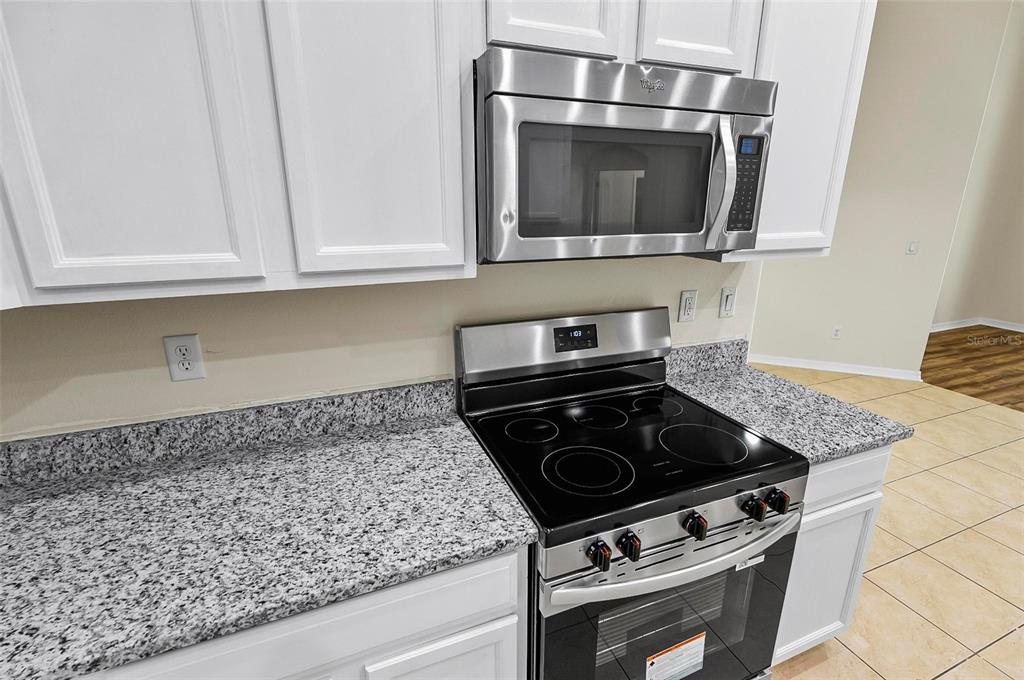 91 Sea Trail Palm Coast, FL 32164 - Photo 54 of 78 a kitchen with granite countertop a stove and a microwave