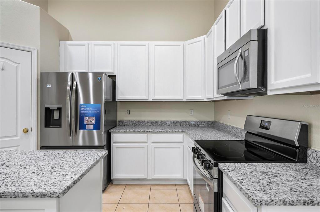91 Sea Trail Palm Coast, FL 32164 - Photo 59 of 78 a kitchen with stainless steel appliances granite countertop a stove a refrigerator and a counter space