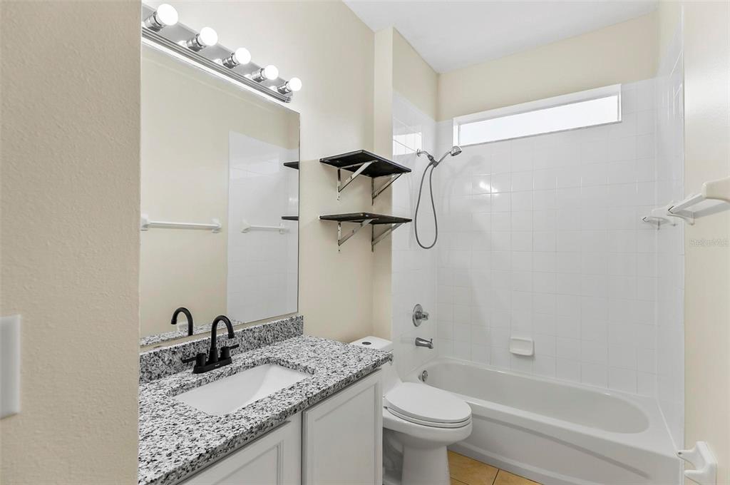 91 Sea Trail Palm Coast, FL 32164 - Photo 62 of 78 a bathroom with a granite countertop sink a toilet and shower