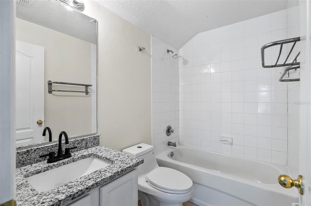 91 Sea Trail Palm Coast, FL 32164 - Photo 63 of 78 a bathroom with a granite countertop sink mirror toilet and bathtub