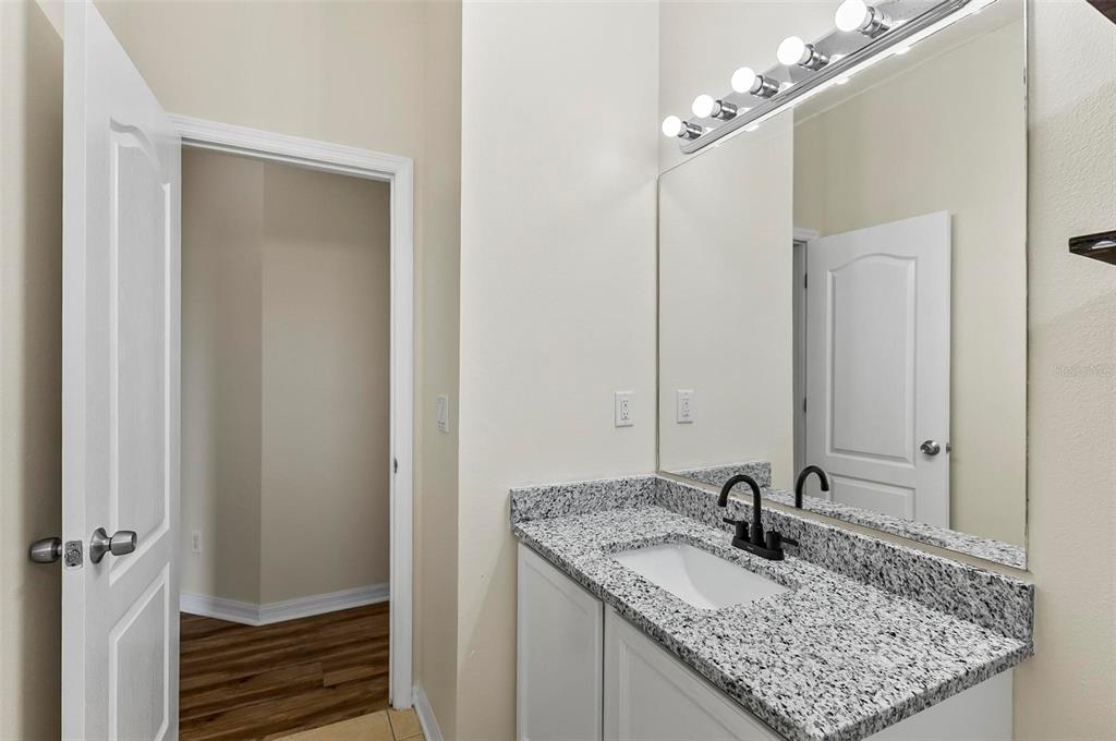 91 Sea Trail Palm Coast, FL 32164 - Photo 65 of 78 a bathroom with a granite countertop sink and a mirror