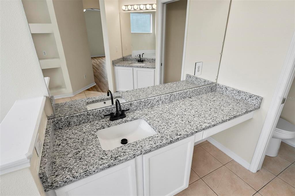 91 Sea Trail Palm Coast, FL 32164 - Photo 68 of 78 a bathroom with a granite countertop sink and a mirror