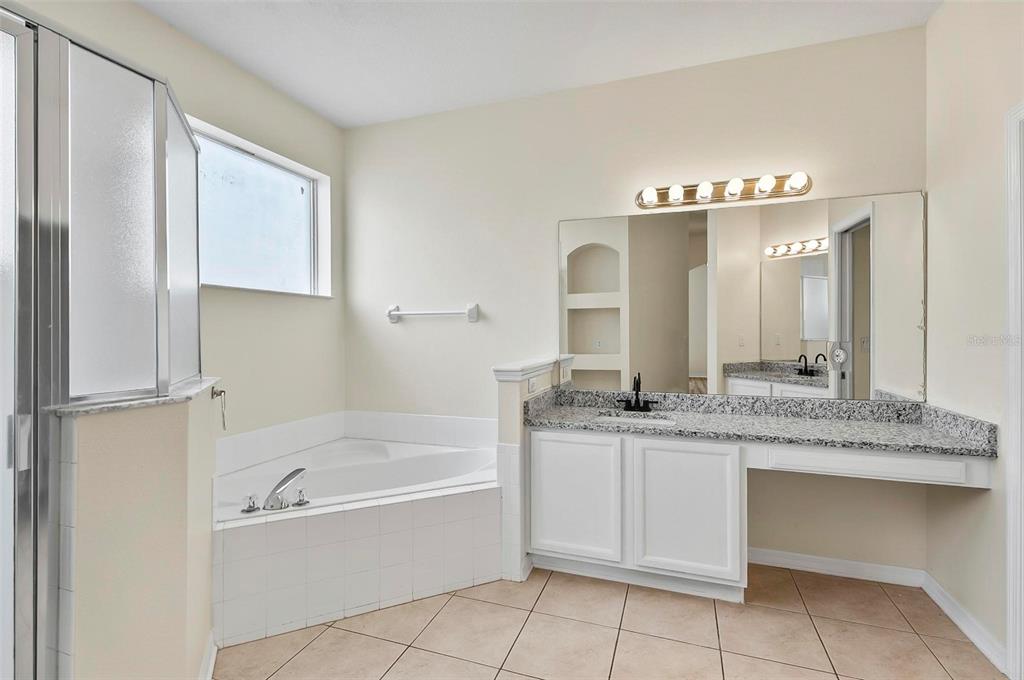91 Sea Trail Palm Coast, FL 32164 - Photo 69 of 78 a bathroom with a granite countertop sink mirror and bathtub