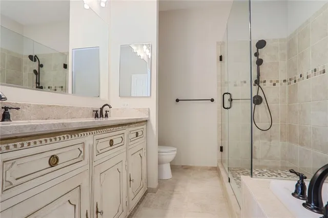 a spacious bathroom with a granite countertop sink a toilet and a shower