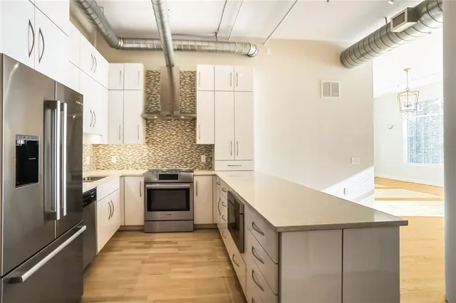 a kitchen with stainless steel appliances granite countertop a stove and a refrigerator