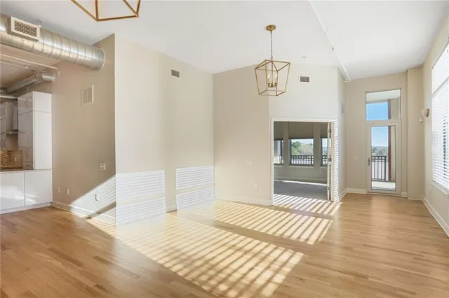 a bedroom with wooden floor a chandelier and windows