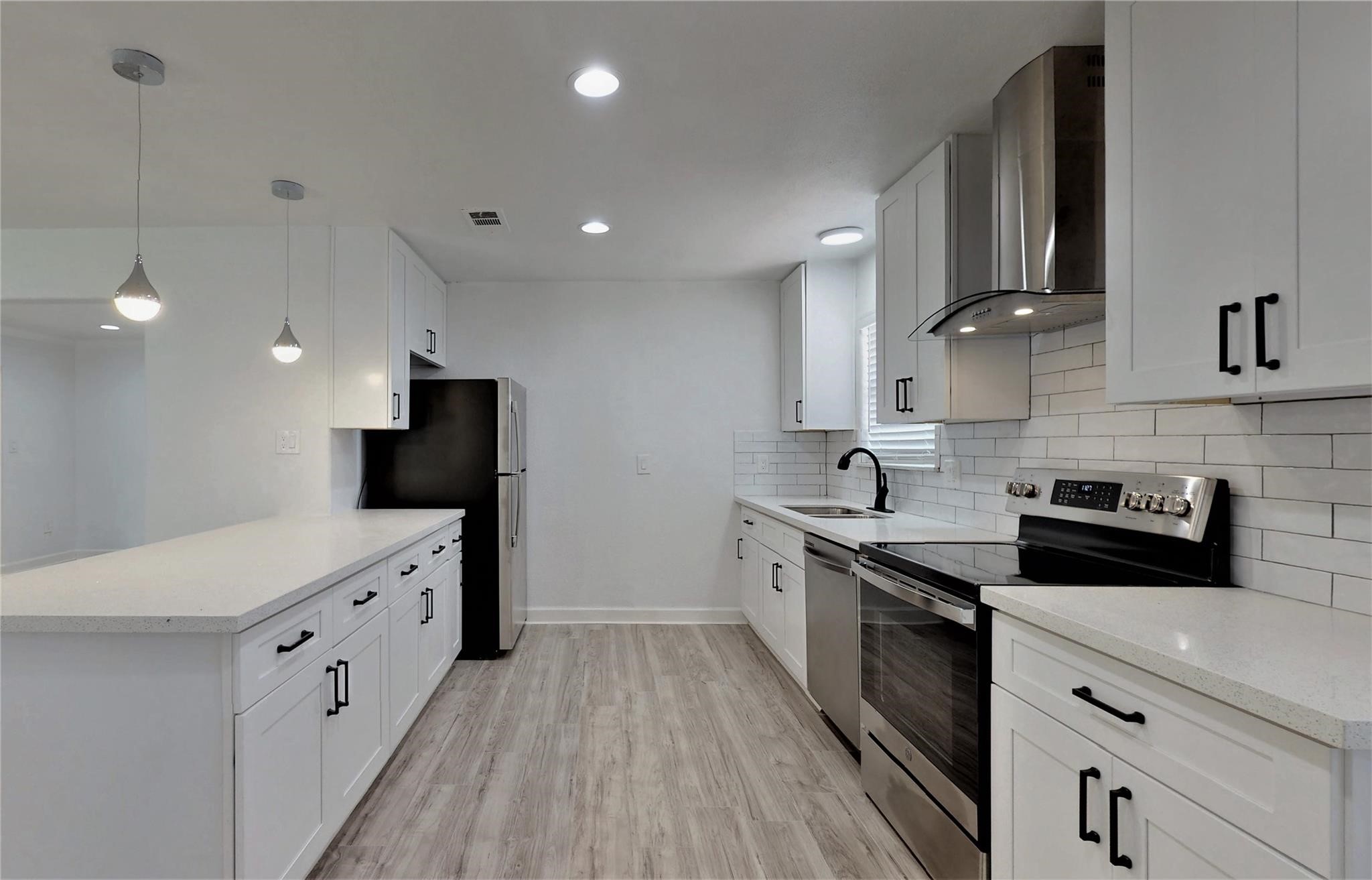 a kitchen with white cabinets sink and stainless steel appliances