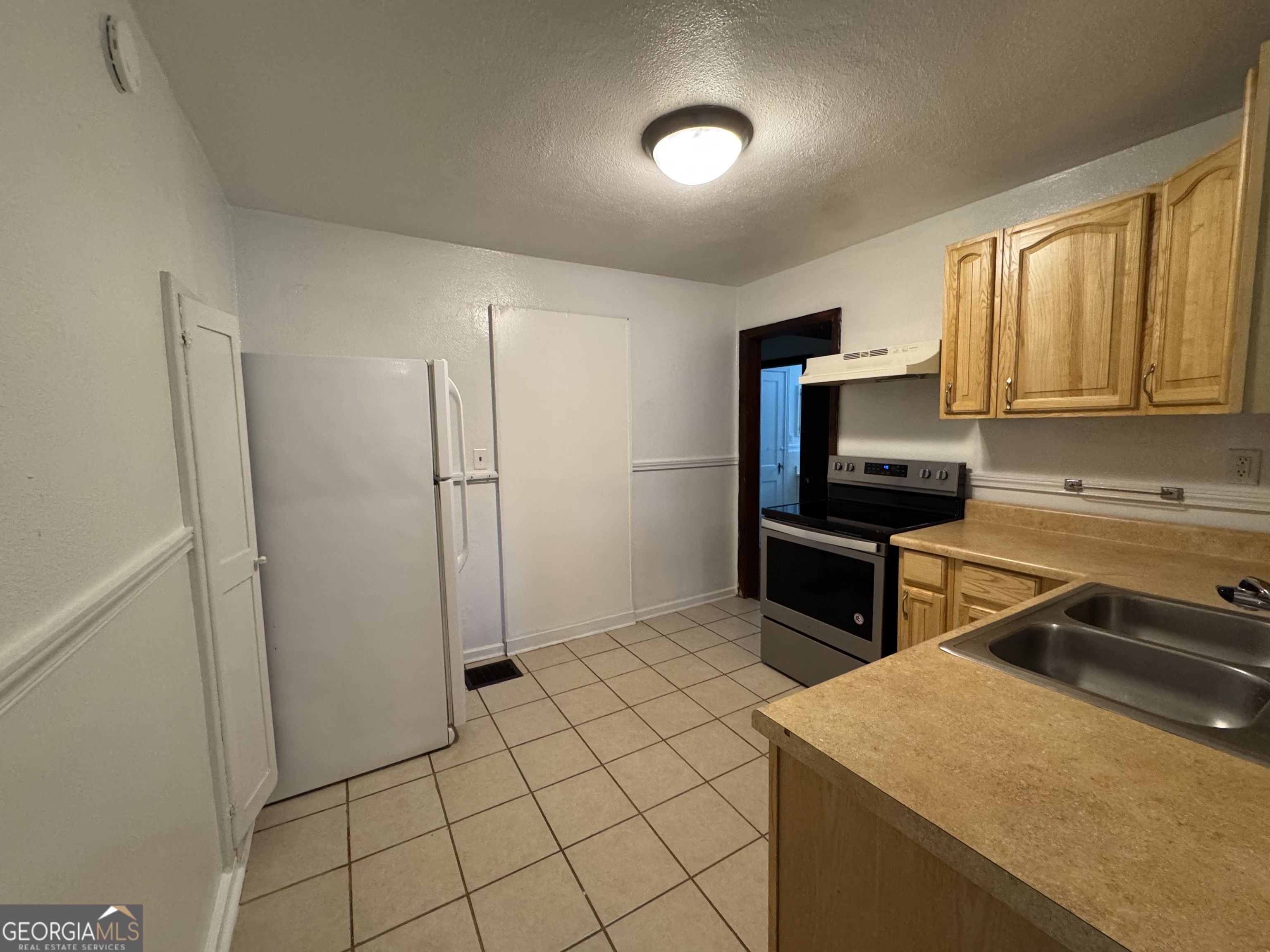 1980 South Lumpkin Street, Unit B Athens, GA 30606 - Photo 7 of 13 a kitchen that has a sink a refrigerator and a stove top oven