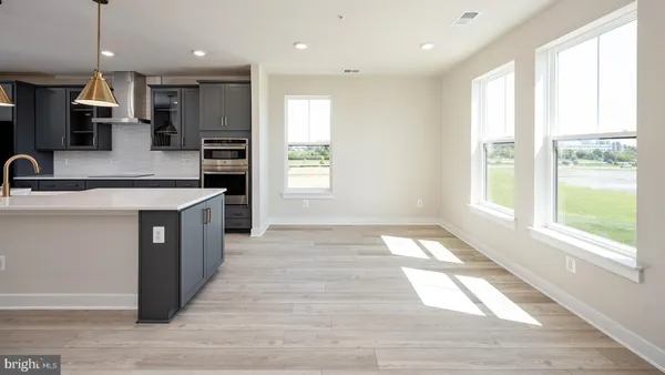 a large kitchen with stainless steel appliances granite countertop a large counter top a stove a sink dishwasher and a large refrigerator