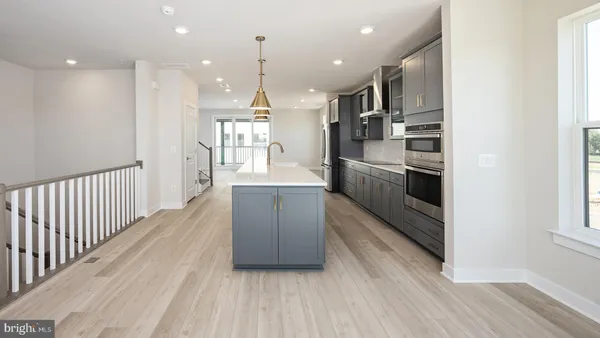 a kitchen with stainless steel appliances a refrigerator and a wooden floors