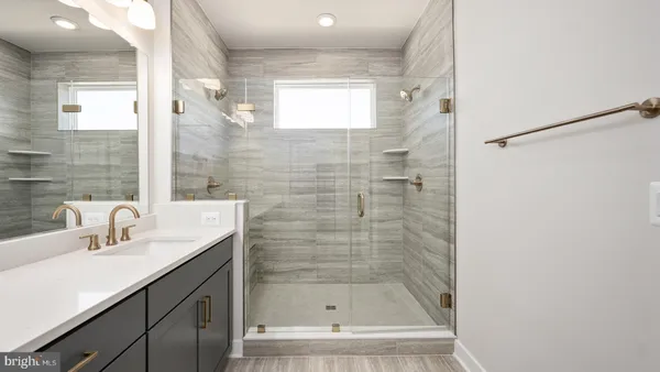 a bathroom with a shower sink and mirror