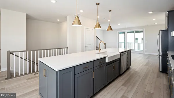 a kitchen with a sink and wooden floor