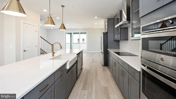 a kitchen with stainless steel appliances kitchen island a large counter space a sink and a stove