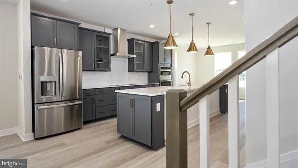 a kitchen with kitchen island granite countertop a refrigerator a oven a sink and a refrigerator