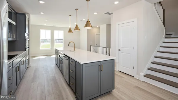 a kitchen with sink a refrigerator and wooden floor