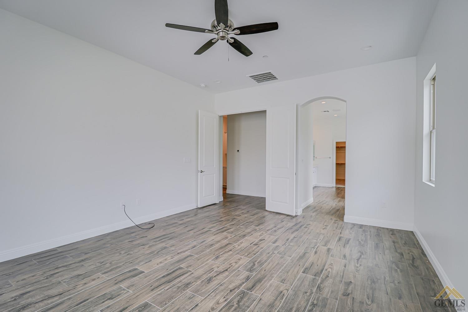 Undisclosed Address Bakersfield, CA 93311 - Photo 27 of 34 an empty room with wooden floor ceiling fan and windows