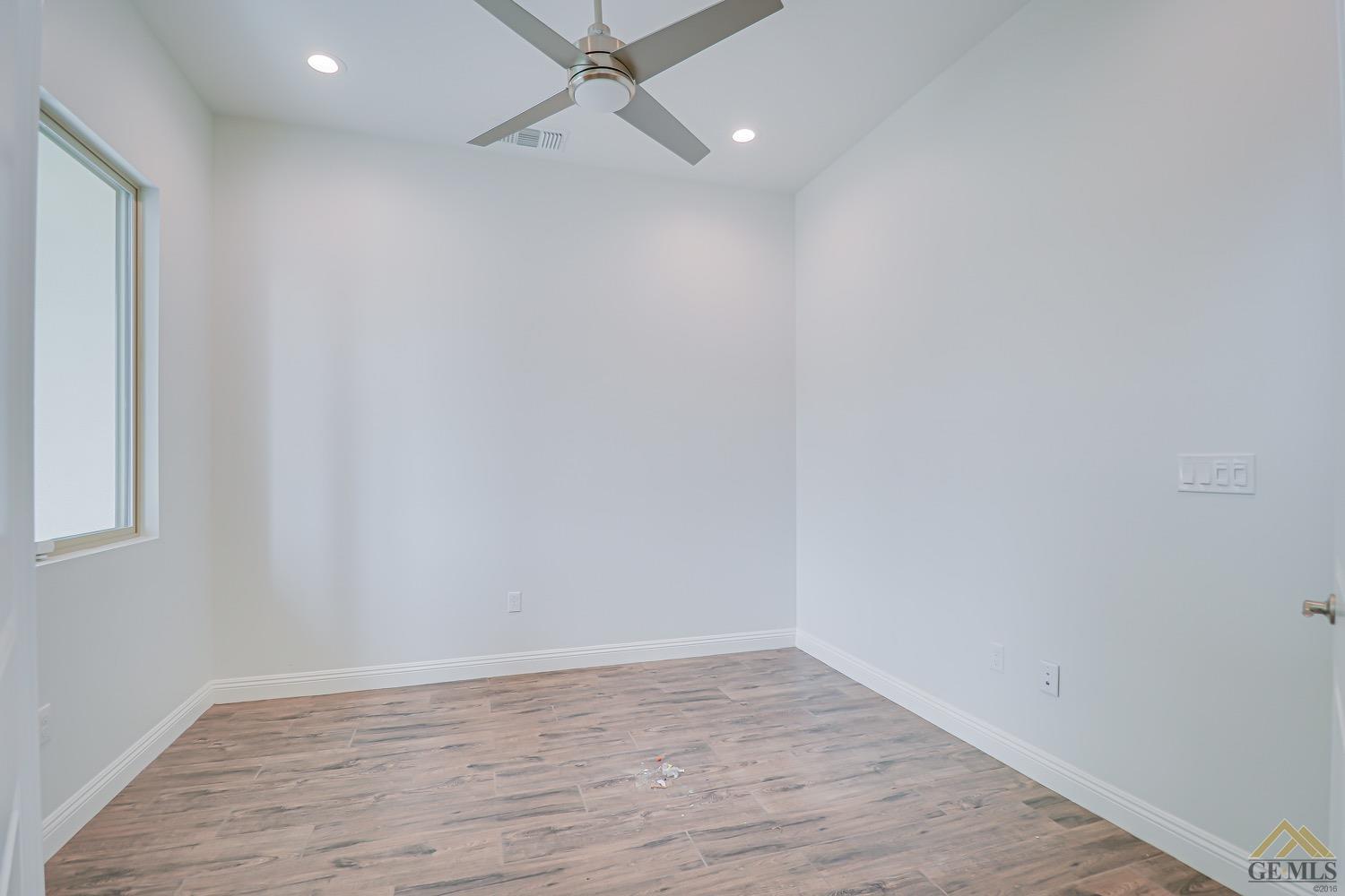 Undisclosed Address Bakersfield, CA 93311 - Photo 10 of 34 a view of an empty room with wooden floor and a window