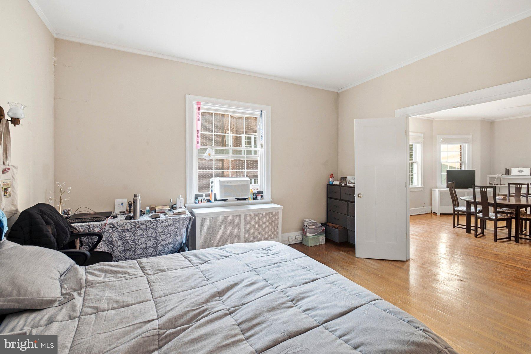101 West 39th Street, Unit C3 Baltimore, MD 21210 - Photo 13 of 28 a bedroom with a bed and wooden floor