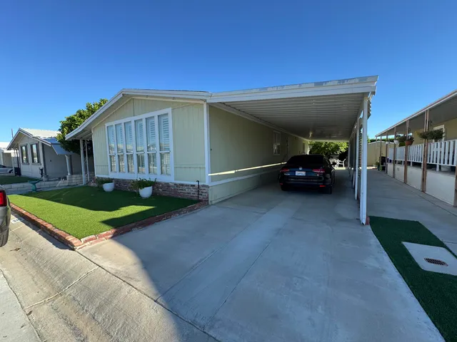 a view of a house with a yard and sitting area