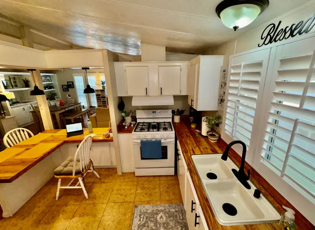 a kitchen with granite countertop a stove and white cabinets