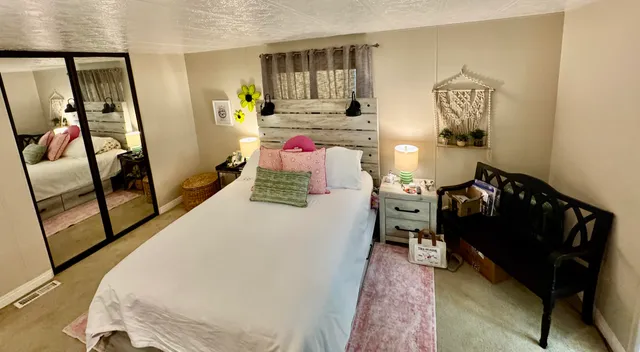 a bed sitting in a bedroom next to a window