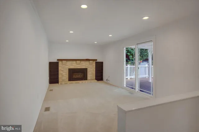 an empty room with a fireplace and large window