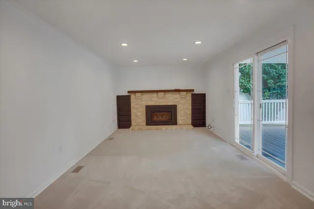 an empty room with a fireplace and a window