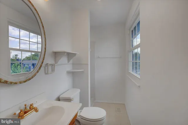 a white toilet sitting next to a window