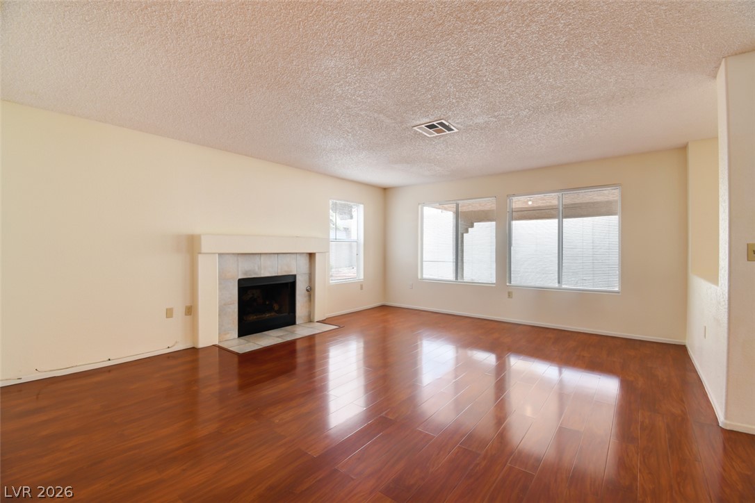 5 Tarryall Terrace Henderson, NV 89074 - Photo 16 of 44 Reflective hardwood flooring complements a cozy fireplace, creating an inviting living space.