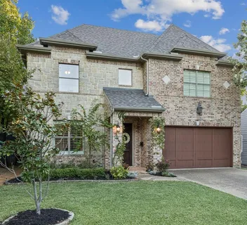 a front view of a house with a garden and yard