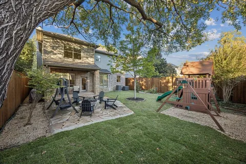 a view of a chair and table in backyard of the house