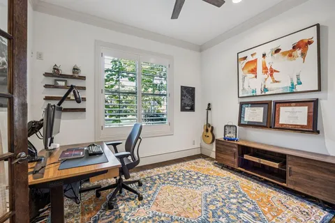 a view of a workspace with furniture and a window