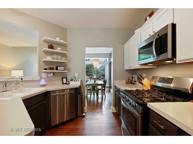 150 Hidden Pond Circle Aurora, IL 60504 - Photo 7 of 15 a kitchen with stainless steel appliances a sink a stove a microwave a sink a counter space and cabinets