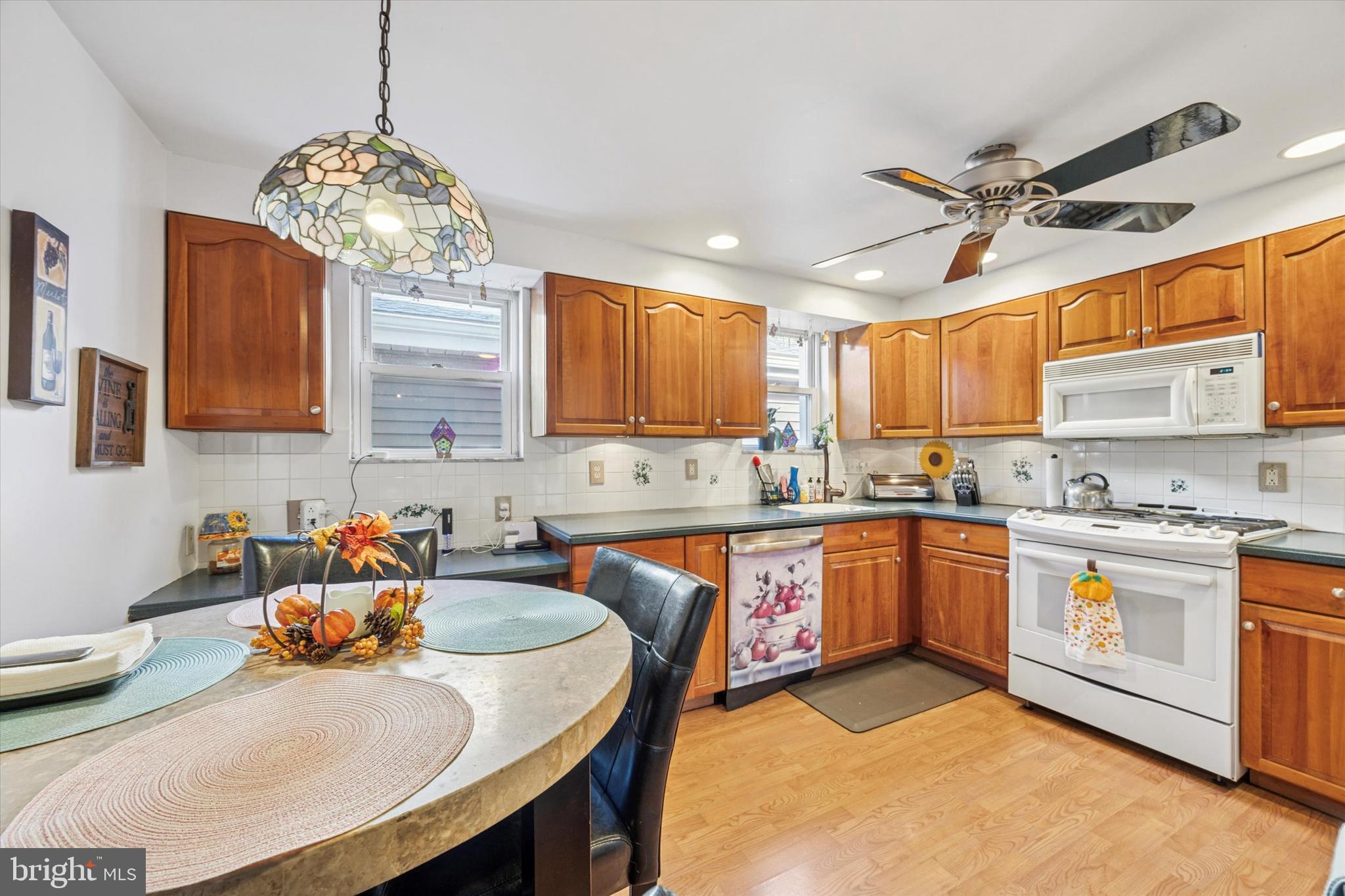 4410 School Lane Drexel Hill, PA 19026 - Photo 11 of 27 a kitchen with stainless steel appliances granite countertop a sink a stove a oven a dining table and chairs