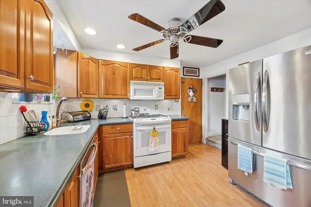 a kitchen with stainless steel appliances sink stove refrigerator and cabinets