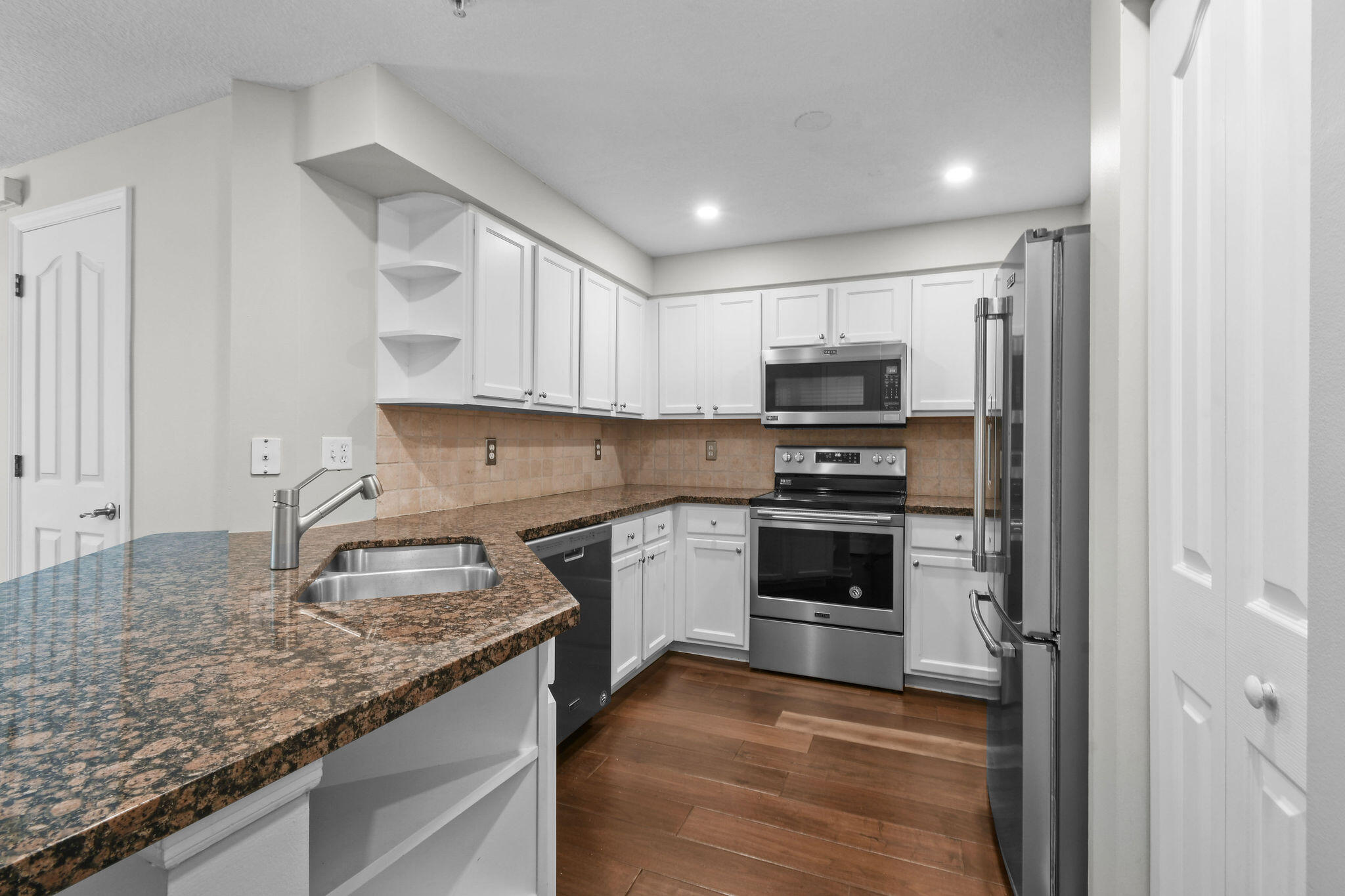175 Galicia Way, Unit 211 Jupiter, FL 33458 - Photo 4 of 49 a kitchen with granite countertop a stove sink and microwave