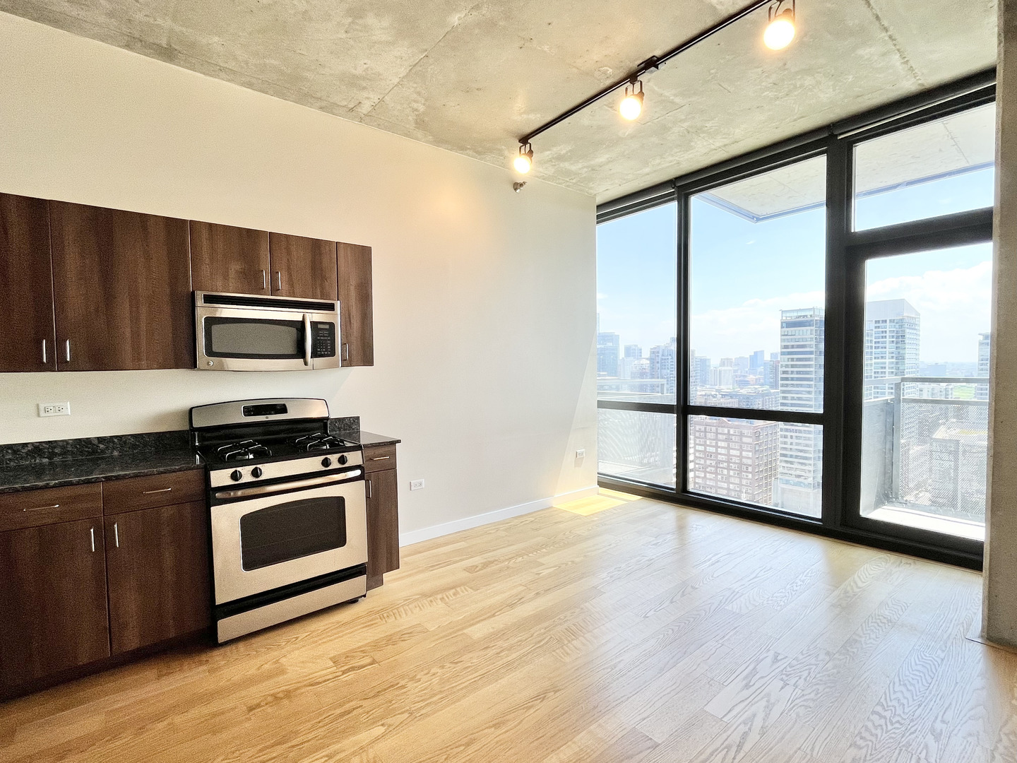 235 West Van Buren Street, Unit 2604 Chicago, IL 60607 - Photo 8 of 21 a kitchen with stainless steel appliances wooden cabinets and a stove top oven