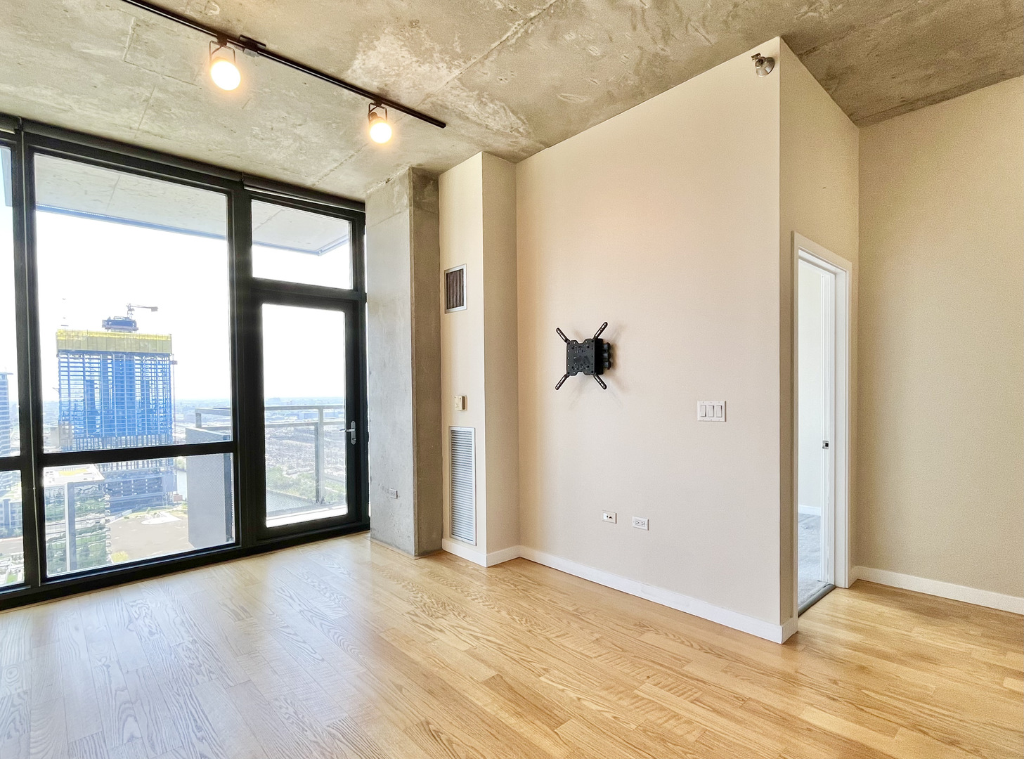 235 West Van Buren Street, Unit 2604 Chicago, IL 60607 - Photo 9 of 21 a view of an empty room with a window and wooden floor