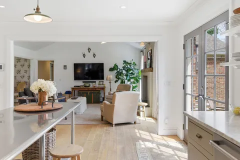 a living room with furniture a flat screen tv and a large window