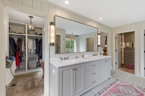 a spacious bathroom with a granite countertop sink and a mirror