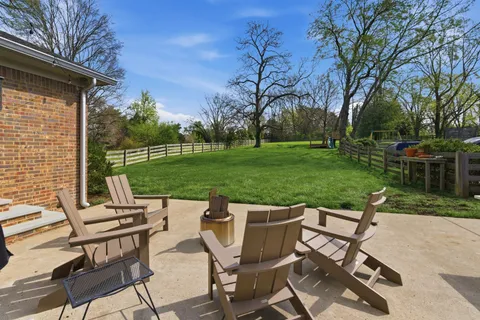 a view of a chairs and table in backyard of the house
