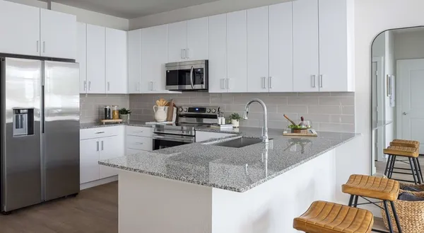 a kitchen with stainless steel appliances granite countertop a sink refrigerator and cabinets