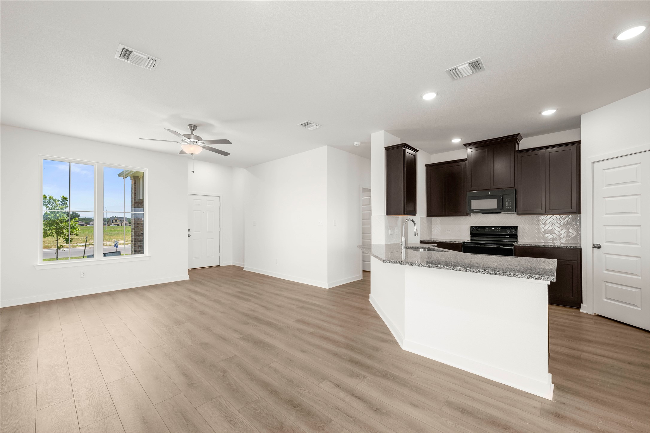228 Gus Loop Georgetown, TX 78626 - Photo 17 of 19 An open concept living area transitions seamlessly to a well-appointed kitchen, ideal for entertaining.